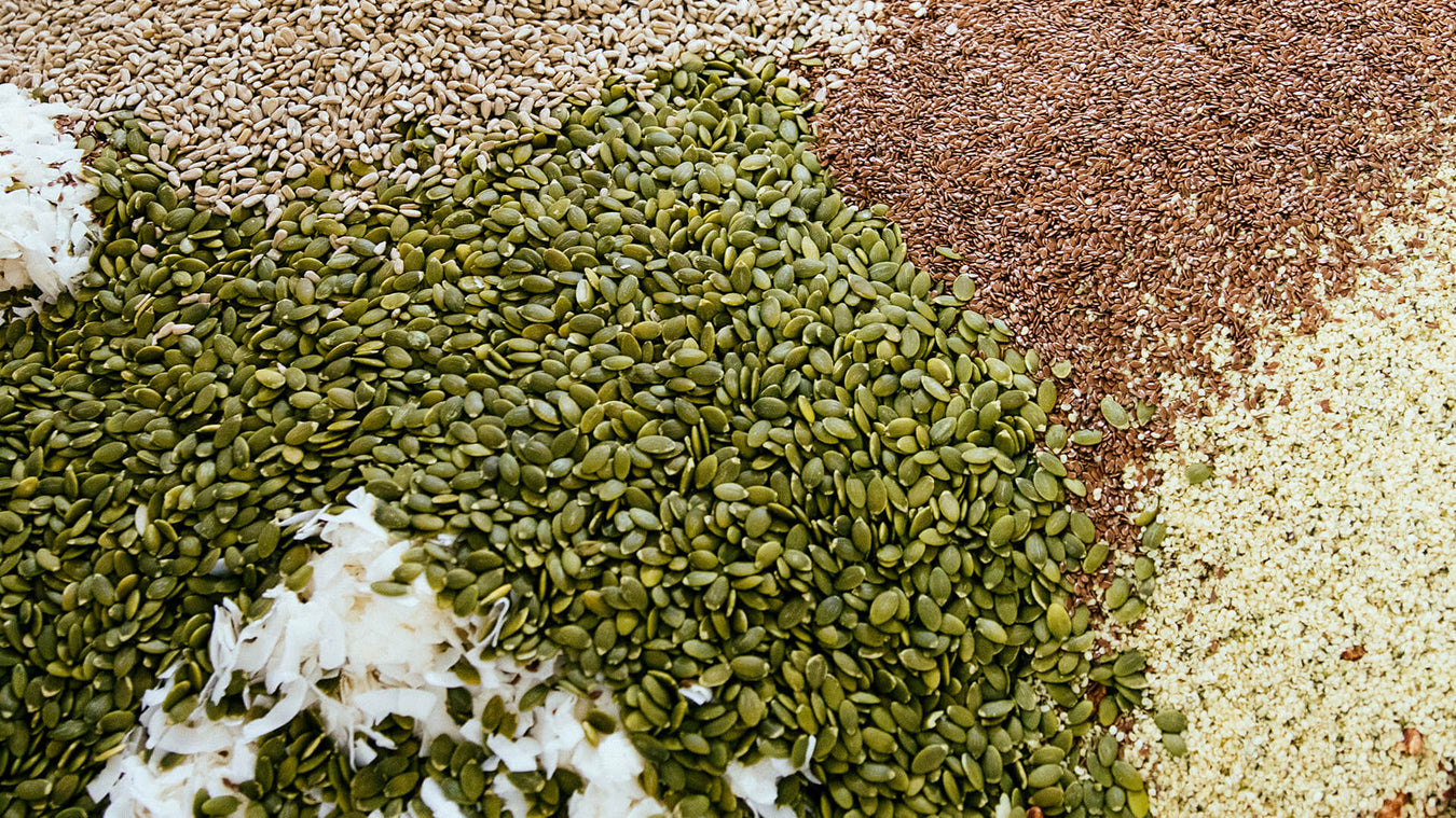 Raw food ingredients including nuts, sunflower seeds, coconut nut flakes mixed together