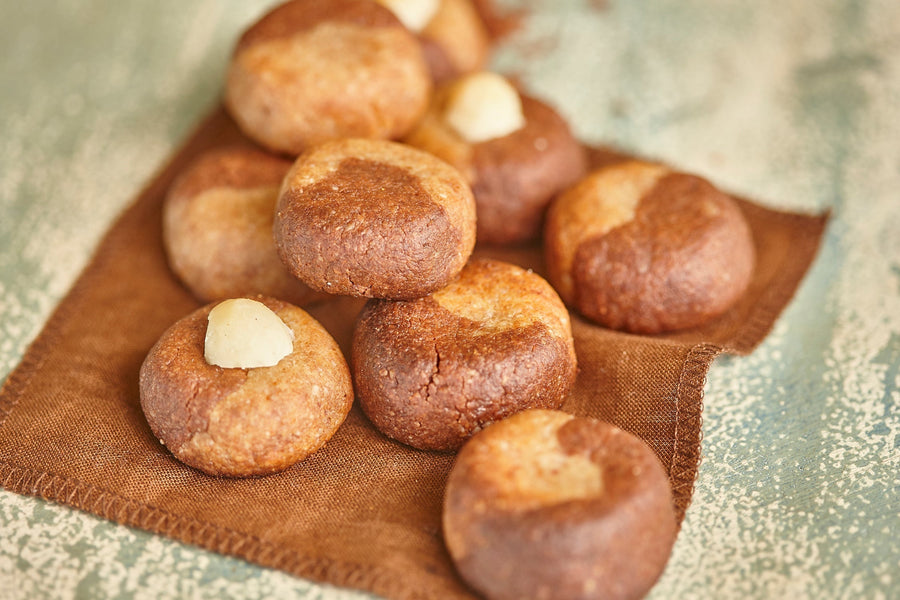 Fudgy macadamia cookies with whole macadamia nuts on a brown linen napkin.
