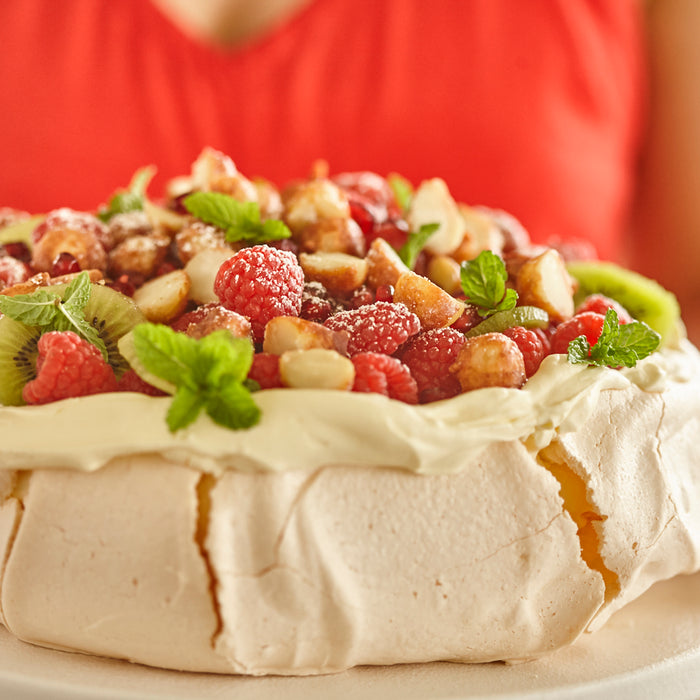 Pavlova with  seasonal fruits  and candied  macadamias