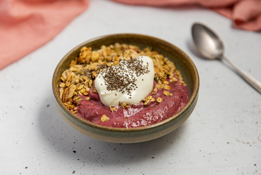 Nutty granola breakfast smoothie bowl topped with yogurt and chia seeds